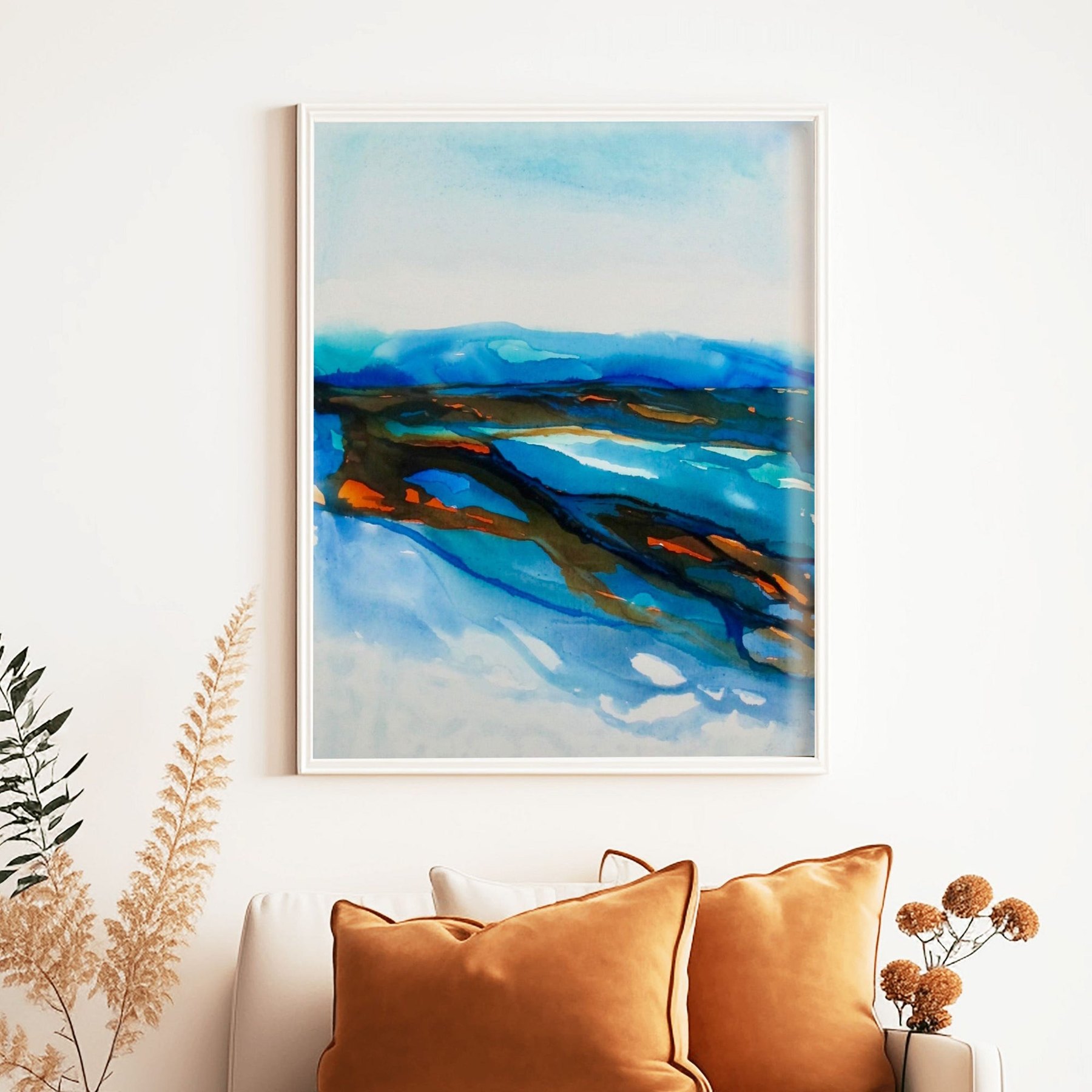 Charlotte George, Waterline abstract coastal painting in blues and amber, framed above a sofa