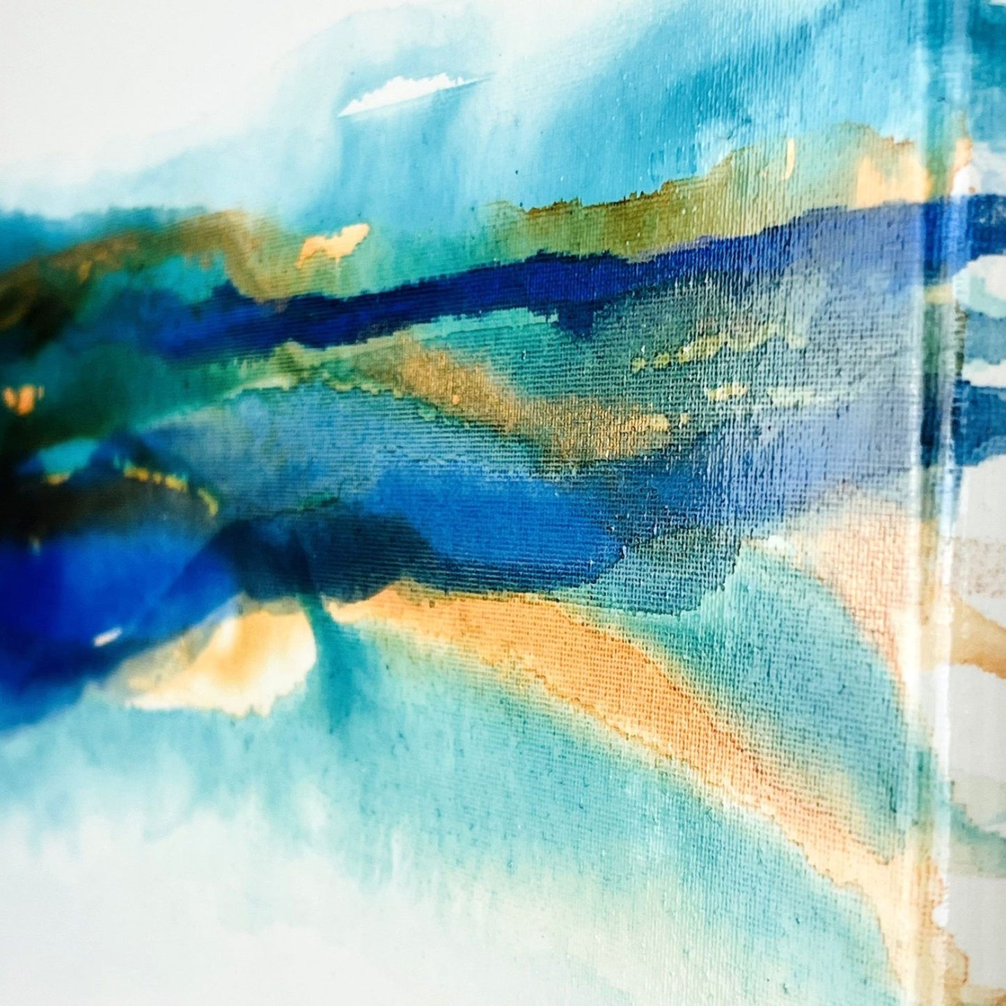 Abstract painting with soft layers of turquoise, brown, and blue ink flowing across a light canvas